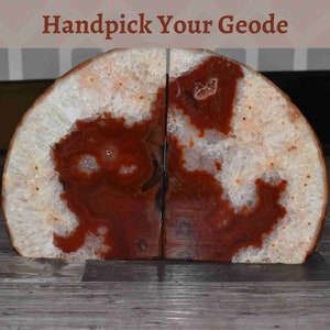 May include: A pair of bookends made from a sliced geode. The geode is a natural formation with a white and red crystal pattern. The bookends are a unique and decorative way to hold books.