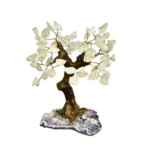 May include: A decorative crystal tree sculpture. The tree features a brown trunk and branches with clear crystal 'leaves'. The base is a purple and white geode. The tree is a unique home decor item.