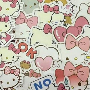 Könnte beinhalten: Eine Sammlung von Hello Kitty-Aufklebern in verschiedenen Posen und Designs. Die Aufkleber zeigen die ikonische Figur mit rosa Schleifen, Herzen und dem Wort "OK". Die Farbpalette umfasst Weiß, Rosa und Gelb.