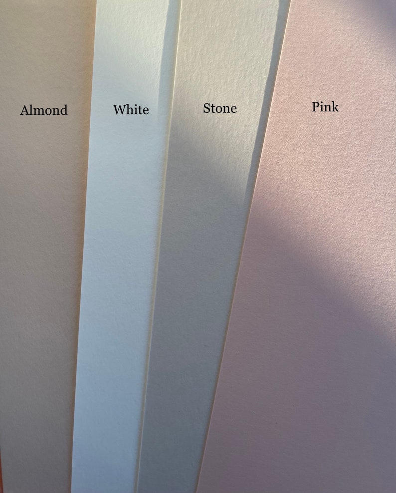 K&ouml;nnte beinhalten: Vier Papierb&ouml;gen in den Farben Mandel, Wei&szlig;, Stein und Rosa. Die Namen der Farben sind auf dem Papier aufgedruckt. Das Papier hat eine strukturierte Oberfl&auml;che und ist diagonal angeordnet, wobei sich das Mandelblatt links und das rosa Blatt rechts befindet.