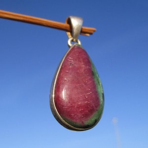 以下が含まれることがあります： シルバーにセットされた緑とピンクの宝石がついた涙型のペンダント