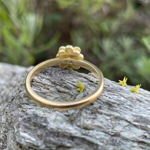 May include: A gold flower ring with a 750 hallmark on the band.