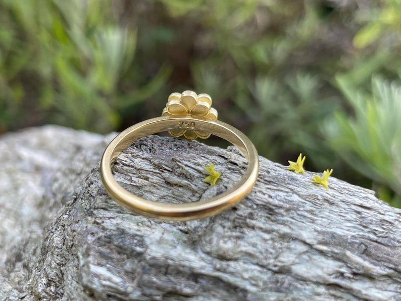 May include: A gold flower ring with a 750 hallmark on the band.