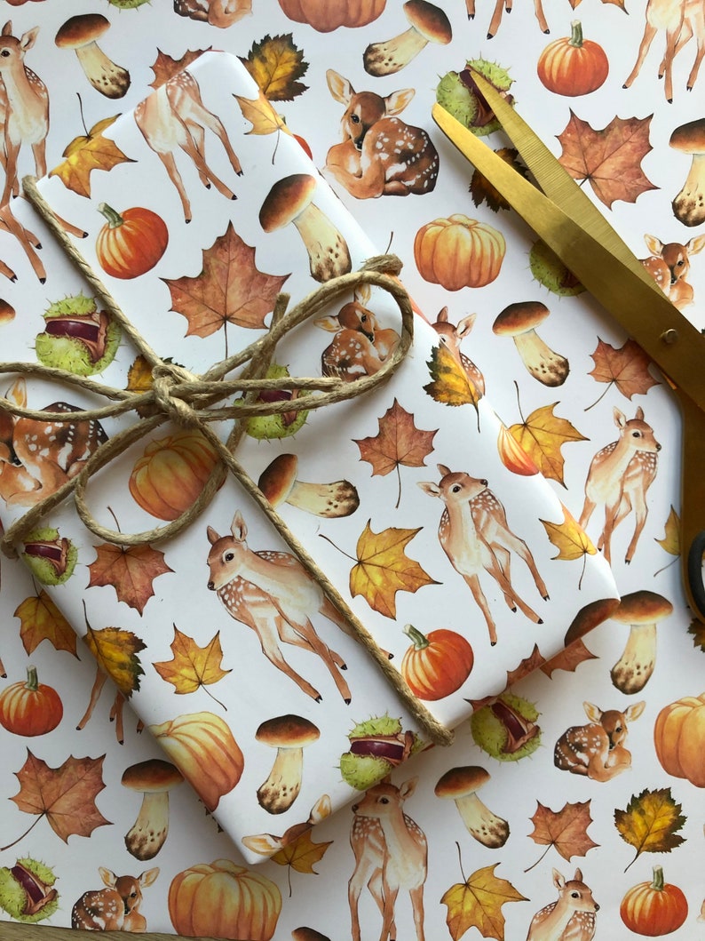 May include: White wrapping paper with a repeating pattern of brown and white deer, orange pumpkins, brown mushrooms, and brown and yellow leaves.