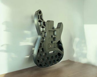 May include: A 3D printed guitar body with a honeycomb design. The body is made of a dark gray plastic and is hollow.