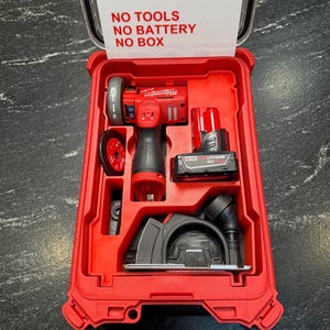 Puede incluir: Maleta de plástico roja que contiene un juego de herramientas eléctricas rojas y negras. El juego incluye una sierra circular, una amoladora y una batería. La tapa de la maleta tiene el texto "INSERT ONLY, NO TOOLS, NO BATTERY, NO BOX."