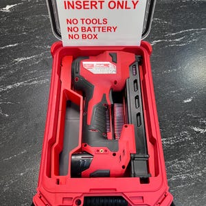 May include: Red and black power tool in a red case. The case lid reads "INSERT ONLY, NO TOOLS, NO BATTERY, NO BOX". The tool is a nail gun, with a black handle and red body. The case is open, revealing the tool inside.