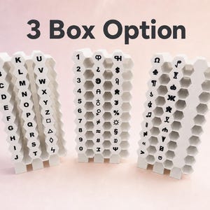 May include: Three white 3D-printed storage organizers with a honeycomb structure. The text 3 Box Option is displayed above. Each organizer features black printed characters, including letters A-Z, numbers 0-9, and various symbols and icons.