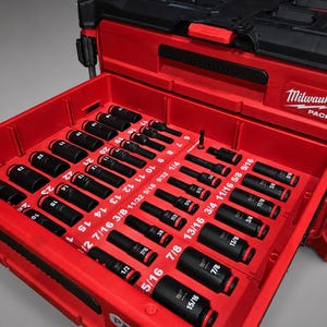 Pode incluir: Uma caixa de ferramentas vermelha Milwaukee Packout com uma gaveta aberta contendo um conjunto de soquetes pretos. Os soquetes estão organizados em uma bandeja vermelha com etiquetas brancas impressas para tamanhos em polegadas e milímetros, incluindo 1/4, 5/16, 3/8, 7/16, 1/2, 9/16, 5/8, 11/16, 3/4, 13/16, 7/8, 15/16 e tamanhos métricos variando de 7 a 24.