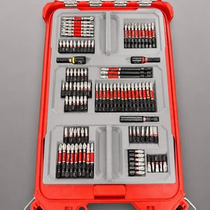 Op de afbeelding: Een rode plastic opbergkoffer met een doorzichtig deksel en een grijze voorgevormde inzet, gevuld met diverse metalen schroefbits en bithouders. De tekst onderaan luidt: INSERT ONLY - NO TOOLS - NO BATTERY - NO BOX.