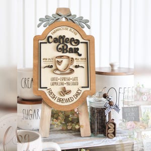 May include: Wooden sign with a coffee bar theme. The sign is brown with white lettering and a coffee cup graphic. The text on the sign reads "Farmhouse Blend Coffee Bar Open 24/7 Self Serve Coffee Espresso Latte Cappuccino Macchiato Fresh Brewed Daily".