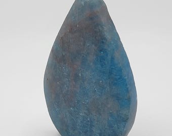 May include: A teardrop-shaped, polished gemstone with a gradient of blue and gray hues. The stone has a smooth, textured surface and a pointed top. The gemstone is displayed against a white background.