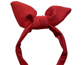 May include: A red fabric headband with a large bow on top.