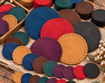 May include: A collection of circular leather pieces in various sizes and colors including red, blue, green, yellow, purple, brown, and black. Each piece features a series of evenly spaced pre-punched holes along the outer edge for stitching.