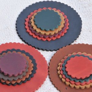 May include: Three sets of layered leather circles, each set with a different color scheme. The first set is black with brown, red, and green circles. The second set is red with brown, black, and purple circles. The third set is brown with tan, green, and red circles.
