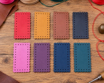 May include: Eight rectangular leather patches with scalloped edges and pre-punched holes along the perimeter. The patches are in red, yellow, brown, black, pink, purple, dark blue, and teal. Spools of colored thread and a metal awl are visible.