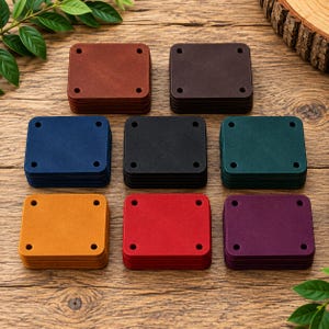 May include: Eight stacks of square leather labels in various colors including tan, dark brown, blue, black, green, yellow, red, and purple. Each label features four pre-punched holes, one in each corner, designed for attachment to garments or crafts.