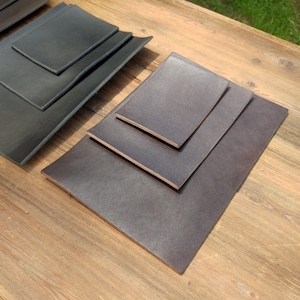 May include: Four ceramic plates in various sizes, stacked on top of each other. The plates are a dark brown color with a slightly textured surface.