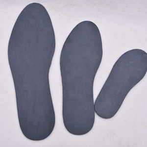 May include: Three gray shoe insoles of different sizes. The insoles are made of a soft, flexible material.