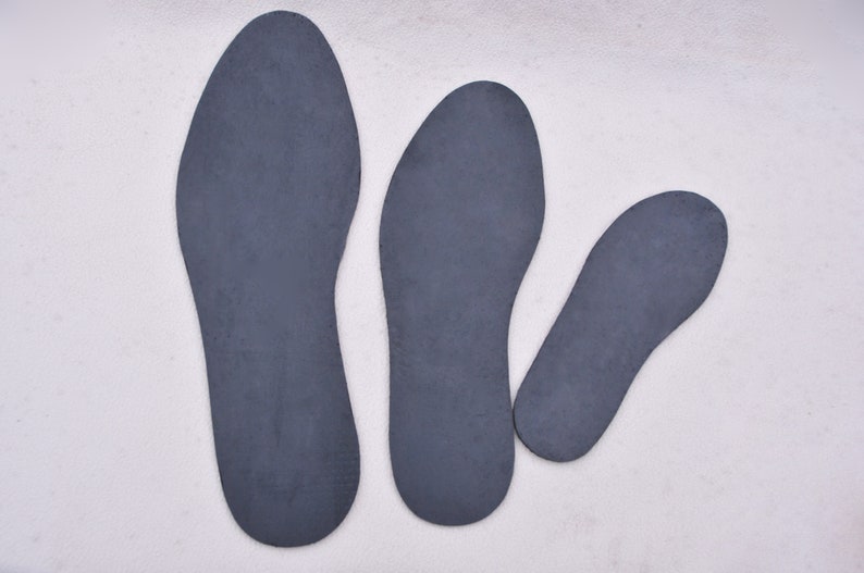 May include: Three gray shoe insoles of different sizes. The insoles are made of a soft, flexible material.