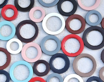 May include: A collection of colorful leather circles with different sizes and colors, including red, blue, white, brown, and pink.