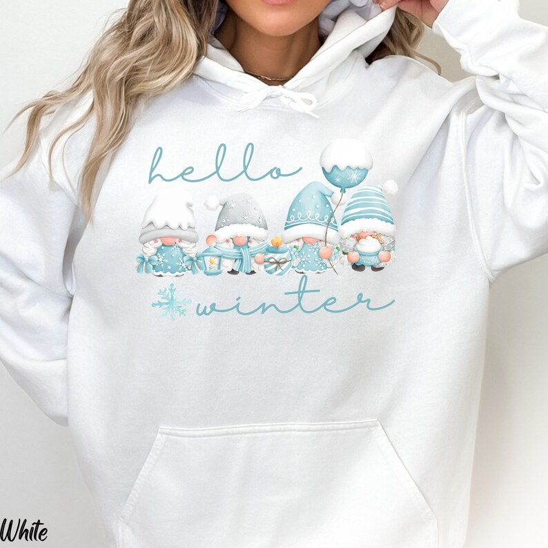 May include: White hoodie with a blue and white graphic of gnomes holding winter-themed items. The text "hello winter" is printed on the hoodie.