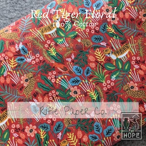 K&ouml;nnte beinhalten: Roter Stoff mit einem sich wiederholenden Muster aus Tigern, Blumen und Bl&auml;ttern. Der Stoff ist aus 100% Baumwolle und tr&auml;gt den Aufdruck "Red Tiger Floral" und "Rifle Paper Co.".