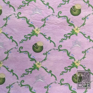 Peut inclure: Un tissu rose avec un motif r&eacute;p&eacute;t&eacute; de vignes vertes, de fleurs bleues et de n&eacute;nuphars verts. Le tissu a une texture subtile et une sensation l&eacute;g&egrave;re et a&eacute;r&eacute;e.