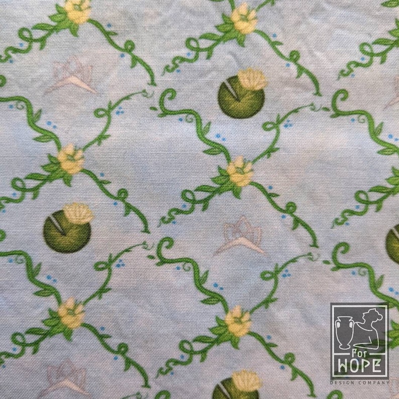 Peut inclure: Un tissu bleu clair avec un motif r&eacute;p&eacute;titif de vignes vertes, de fleurs jaunes et de n&eacute;nuphars verts. Le tissu a une texture subtile et un fond bleu clair.