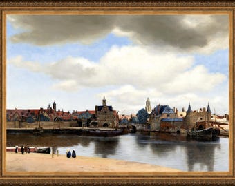 May include: A framed oil painting depicting a 17th-century Dutch cityscape along a riverbank. The scene features stone buildings with red roofs, a harbour with moored boats, and a sandy foreground with small figures under a large, cloudy blue sky.