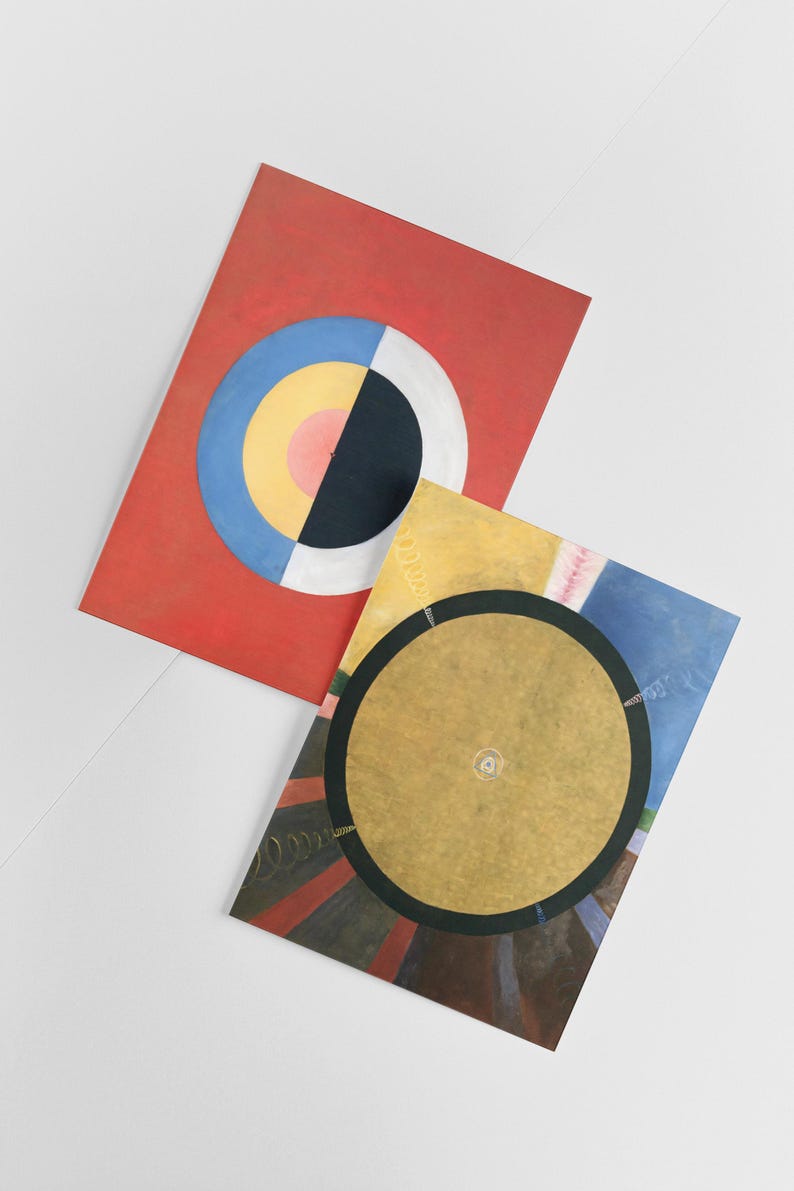 Puede incluir: Dos pinturas abstractas con c&iacute;rculos conc&eacute;ntricos. La primera pintura es roja con un c&iacute;rculo azul, amarillo, rosa y negro. La segunda pintura es amarilla con un c&iacute;rculo dorado rodeado por un anillo negro y un fondo colorido.