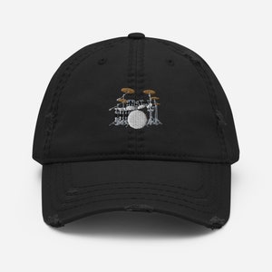 Puede incluir: Gorra de béisbol negra desgastada con una imagen bordada de una batería. La batería es plateada con platillos marrones.