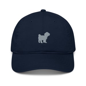 Puede incluir: Una gorra de béisbol azul marino con una silueta de perro bordada en gris en la parte delantera.