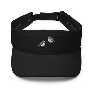 May include: Black visor with a small embroidered design of two birds facing each other. The visor has a black strap with the text "110 FIT" on it.