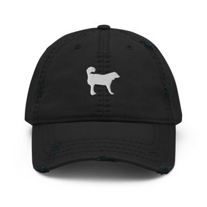 Puede incluir: Una gorra de béisbol negra desgastada con una silueta de perro bordada en blanco.