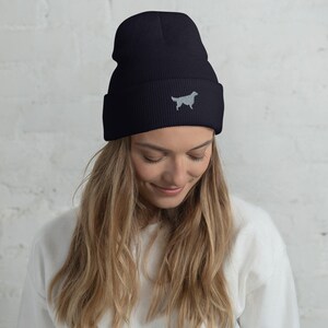 May include: Black beanie with a white embroidered silhouette of a golden retriever.