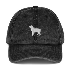 May include: A black vintage washed denim baseball cap with a white embroidered silhouette of a dog on the front.