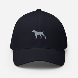 Op de afbeelding: Een donkerblauwe baseballpet met een geborduurd grijs silhouet van een hond.