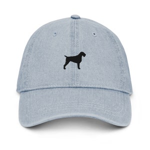 May include: A light blue denim baseball cap with a black embroidered silhouette of a German Shorthaired Pointer dog.