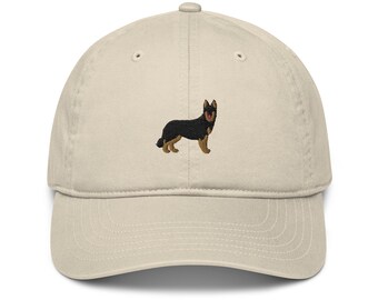 May include: A beige baseball cap with an embroidered black and brown German Shepherd dog.