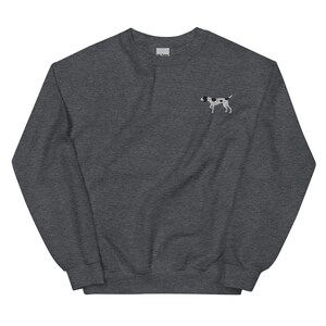 Op de afbeelding: Een donkergrijs sweatshirt met een klein geborduurd beeld van een zwart-witte hond op de linker borst.