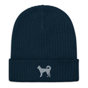 May include: A dark blue knitted beanie with a gray embroidered silhouette of a dog on the front.