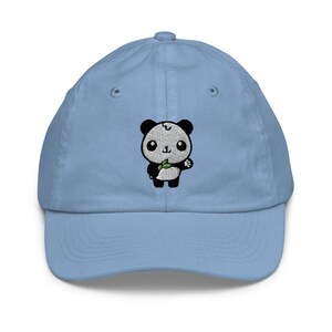 Può includere: Un cappello da baseball blu chiaro con un panda nero e bianco ricamato che tiene un germoglio di bambù.