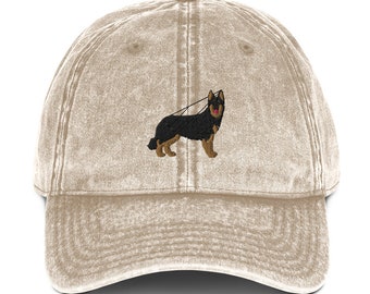 May include: A beige, distressed, vintage-style baseball cap with an embroidered black and brown German Shepherd dog on the front.