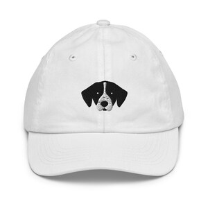 May include: White cotton baseball cap with a black and white embroidered dog face on the front.