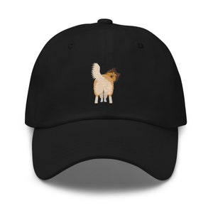 May include: A black baseball cap with an embroidered image of a brown and white dog looking over its shoulder.