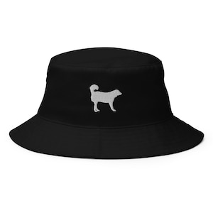 Puede incluir: Sombrero de pescador negro con una silueta de perro bordada en blanco.