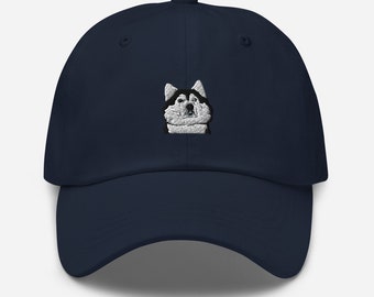 May include: A navy blue baseball cap with an embroidered image of a husky dog's face.