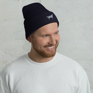May include: A navy blue beanie with a grey embroidered dog silhouette.