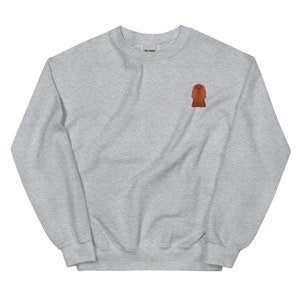 May include: A grey sweatshirt with a small embroidered image of a red dog on the left chest.